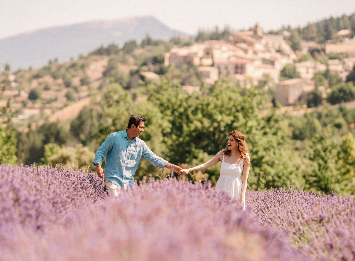 couple laugh and walk in lavender field