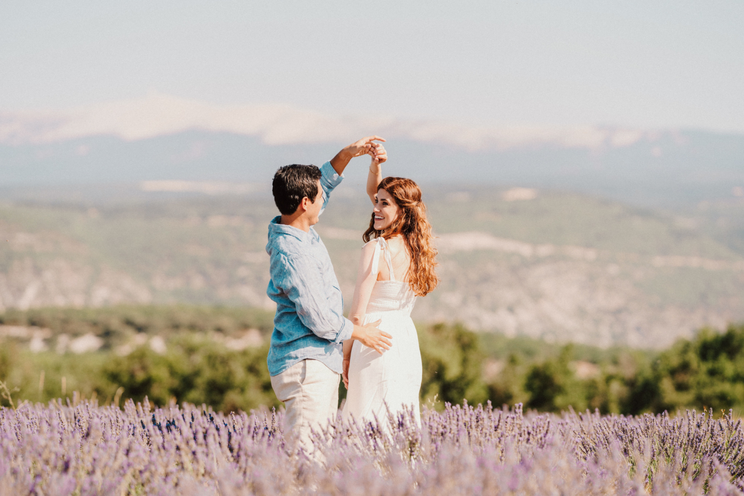 man twirls woman in lavender field