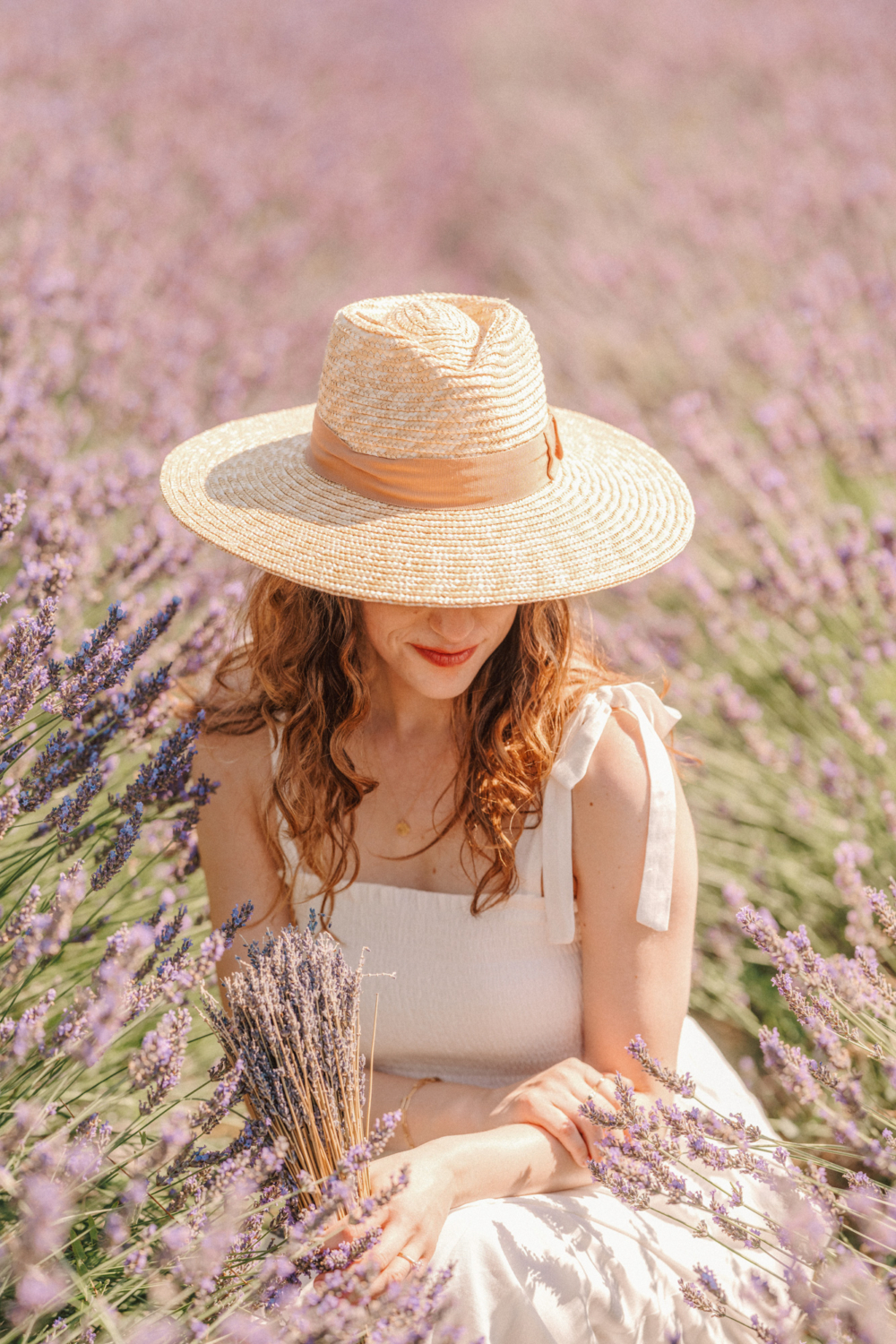 woman in hat poses in lavender field