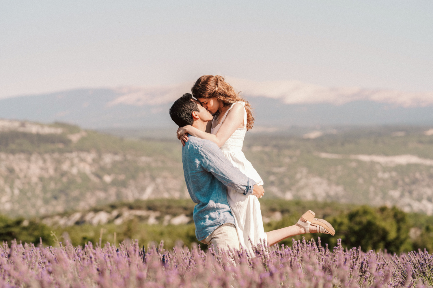 couple embrace in a kiss in a lavender field