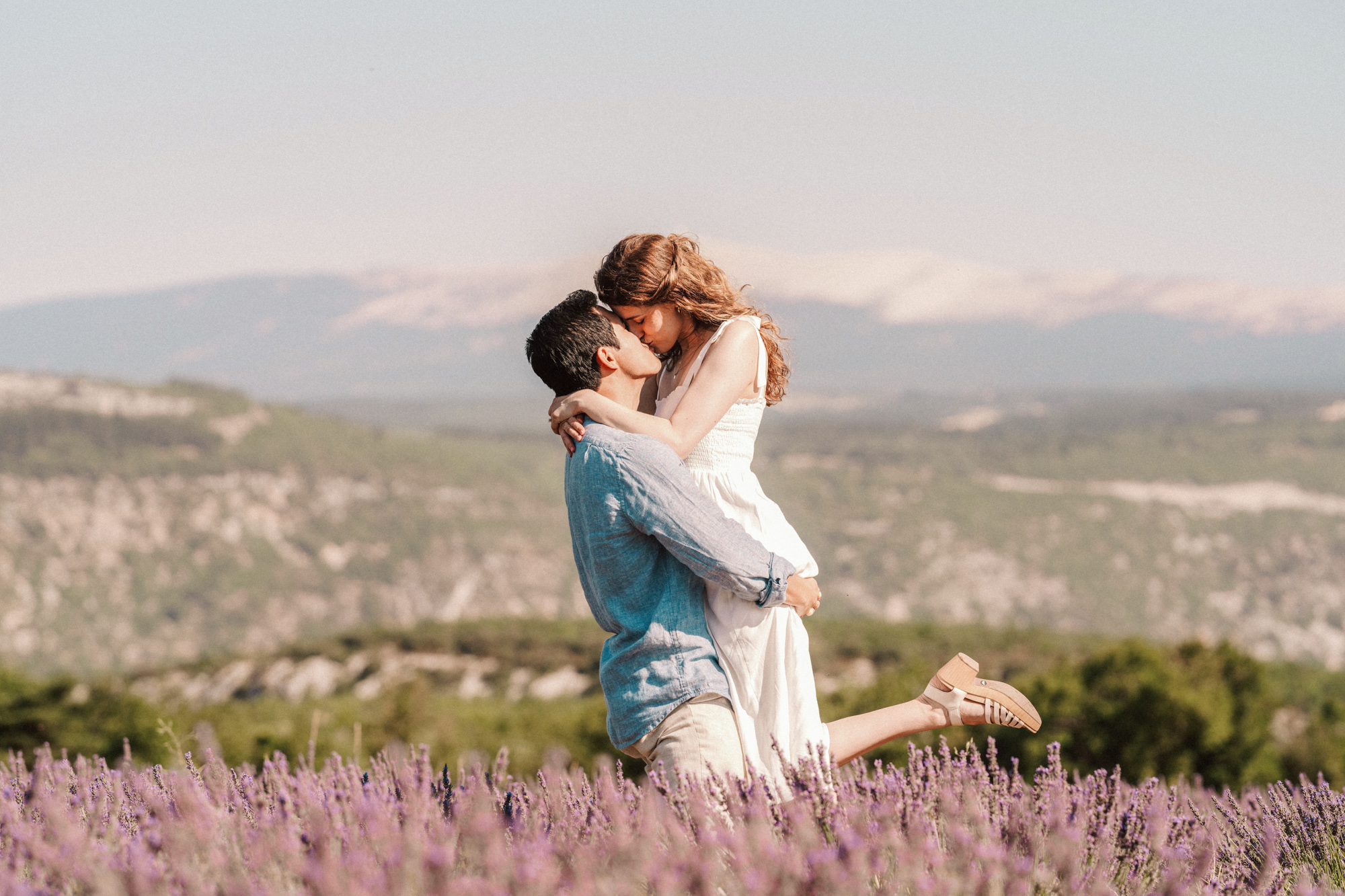 couple embrace in a kiss in lavender fields of Provence