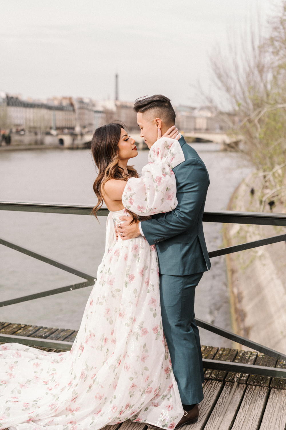asian couple pose on bridge in paris