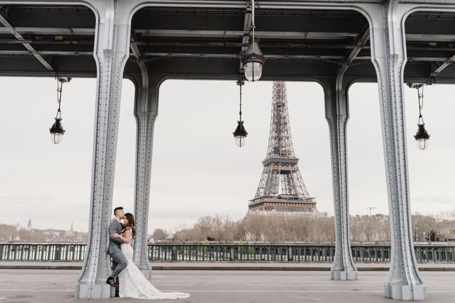 asian wedding couple embracing with view of eiffel tower in paris