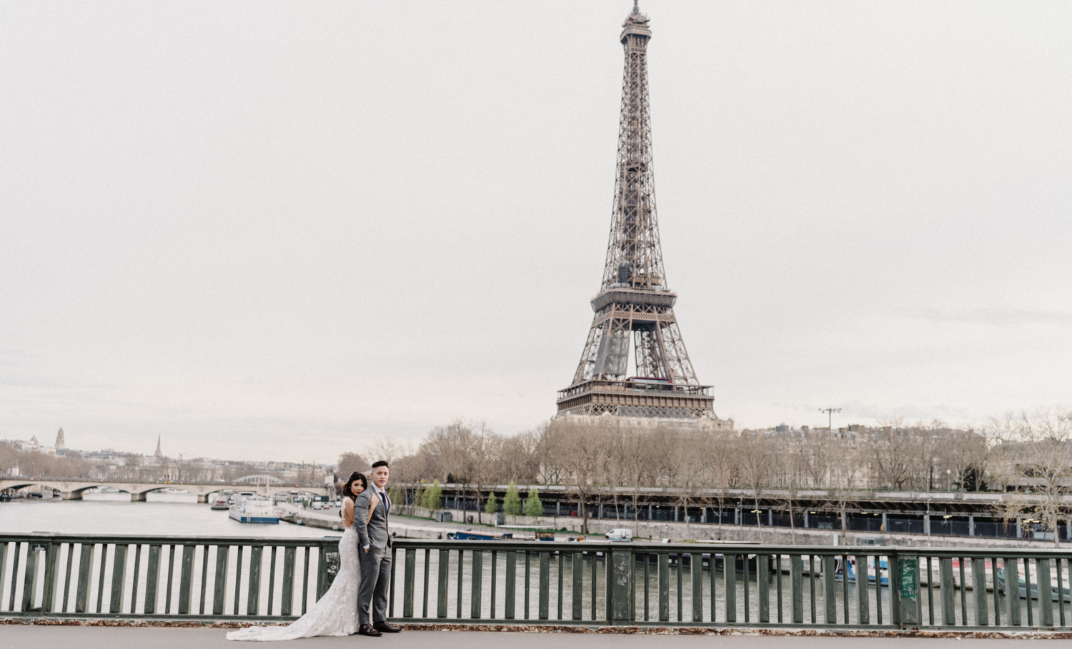 asian wedding couple posing with view of eiffel tower