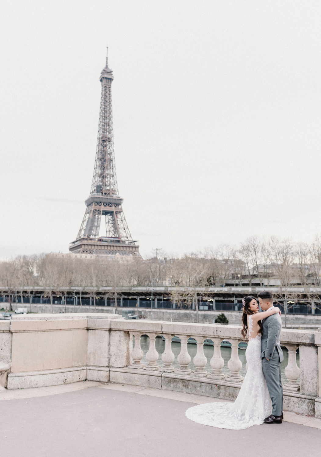 asian wedding couple pose with view of eiffel tower in paris
