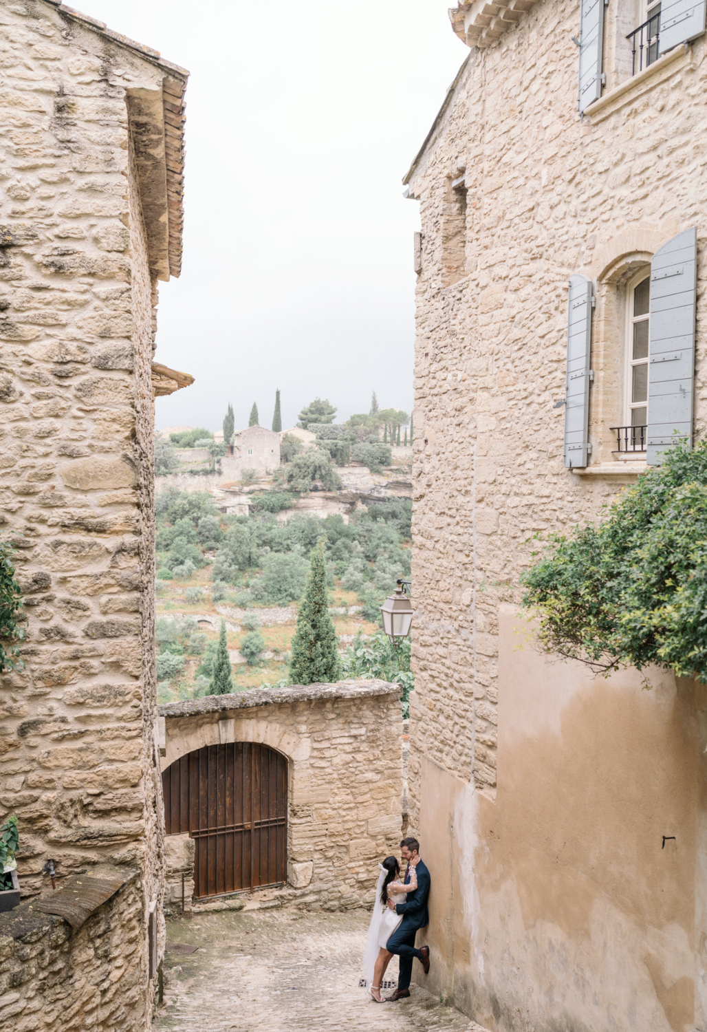 bride and groom embrace with amazing view of gordes france