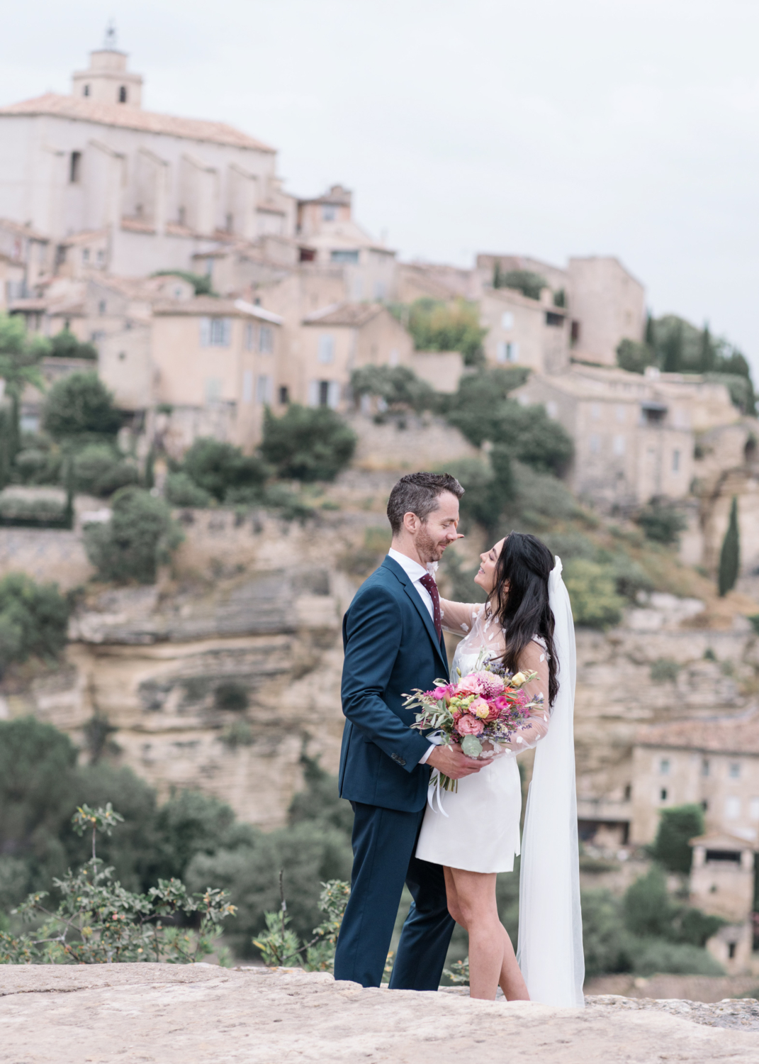 bride and groom look at each other affectionately in gordes france