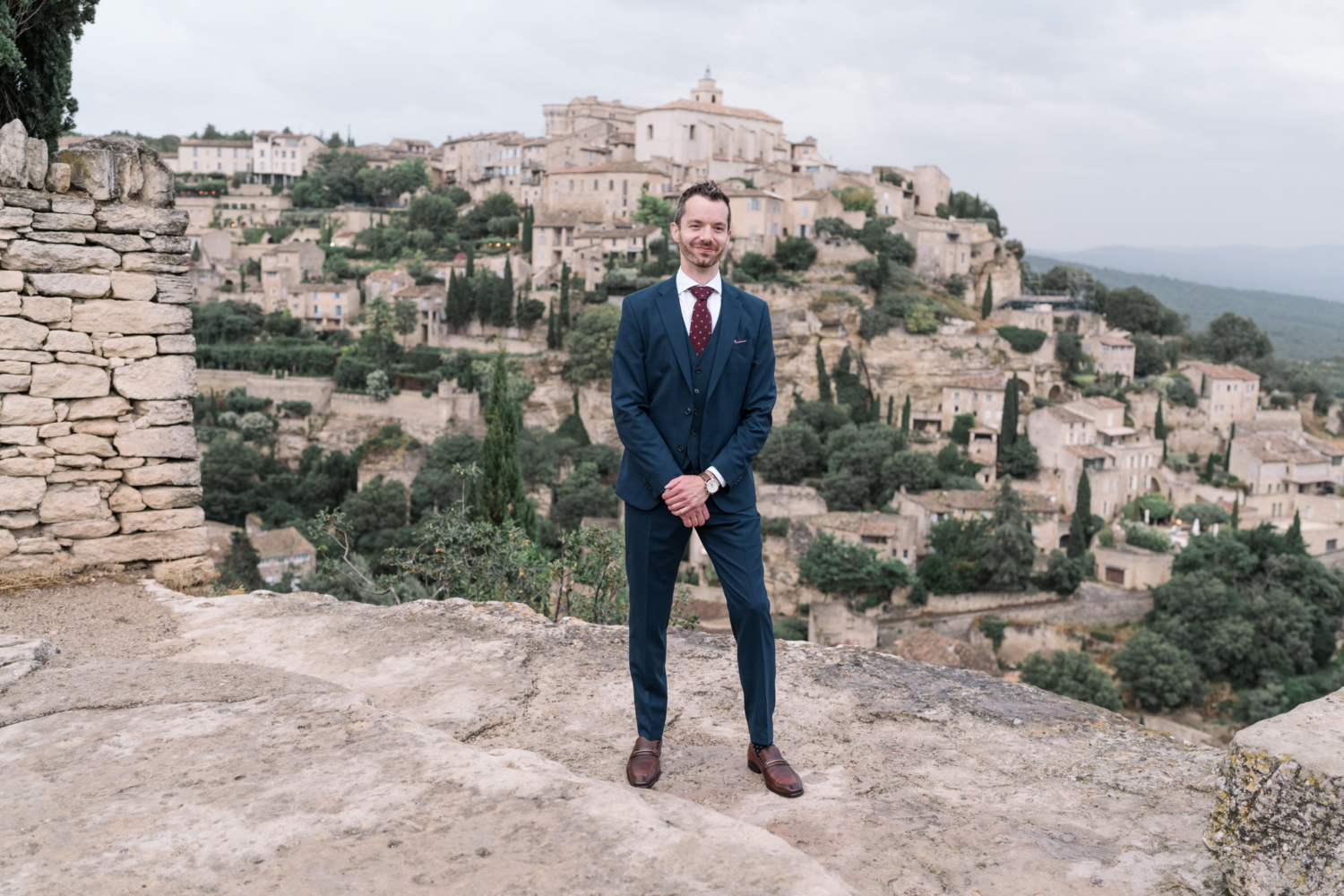 handsome groom poses in gordes france