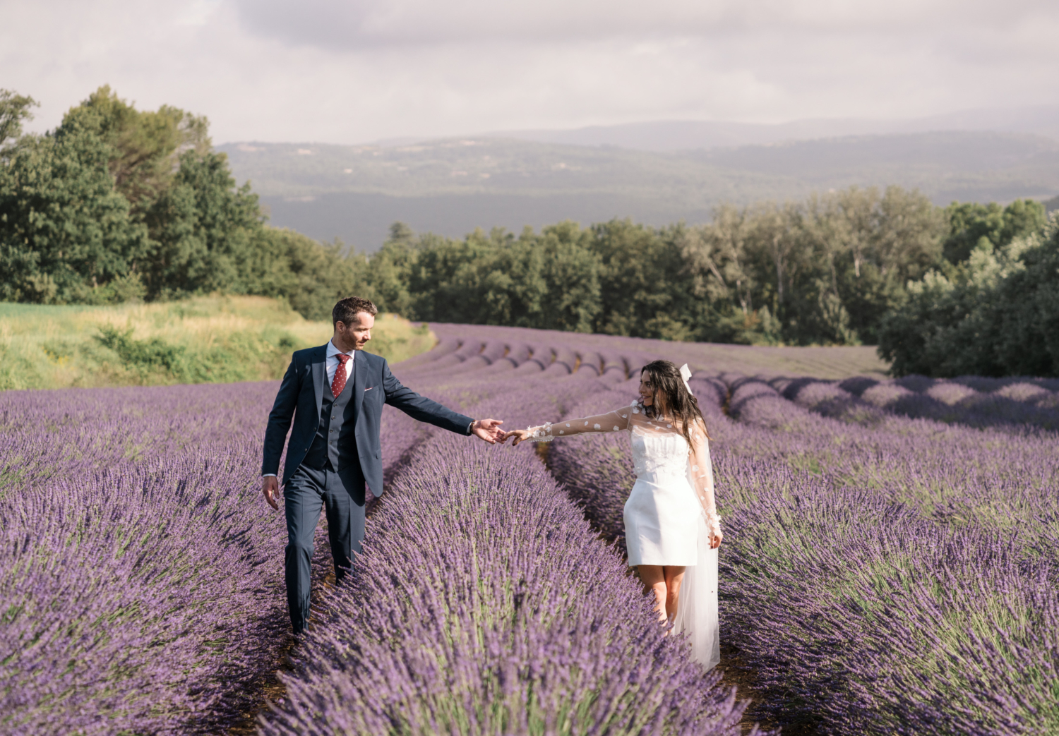 bride and groom walk through a lavender field in provence france