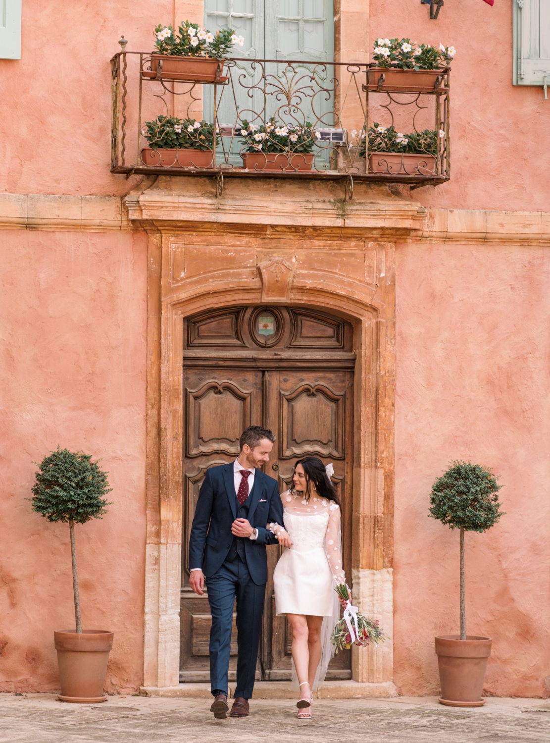 bride and groom walk arm in arm in roussillon france