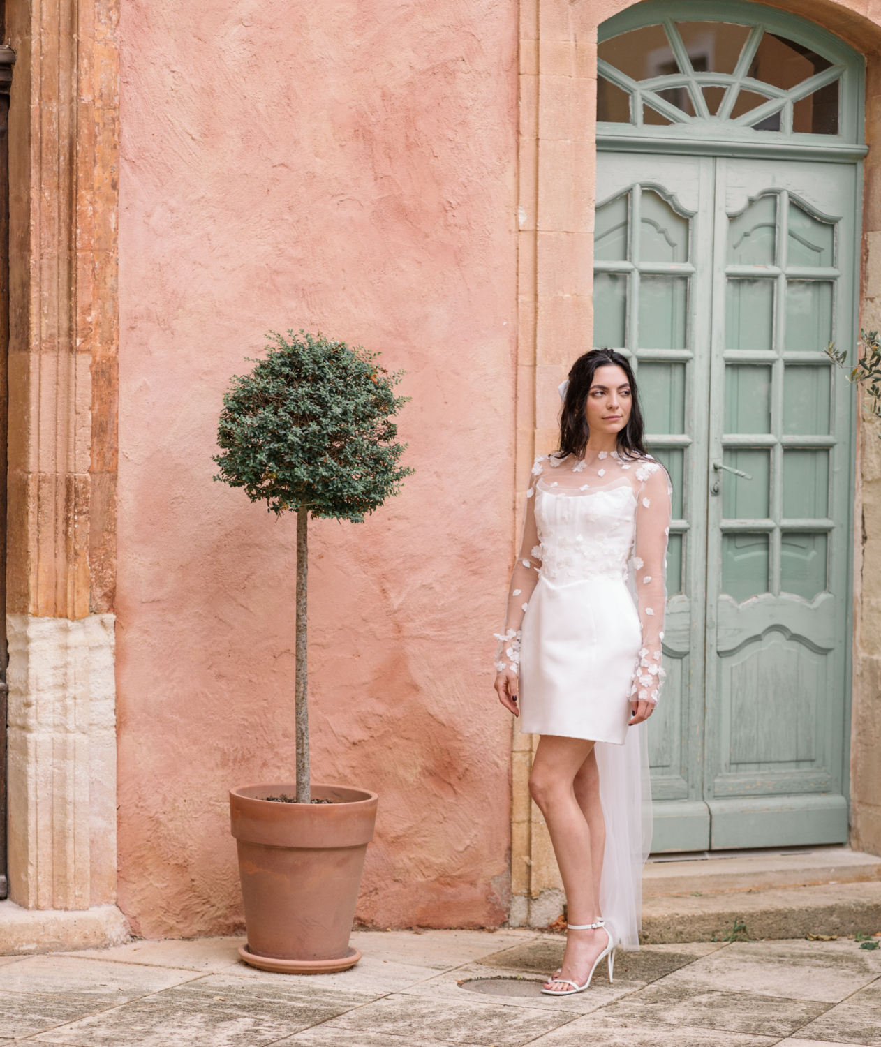 beautiful bride poses in front of city hall in roussillon france