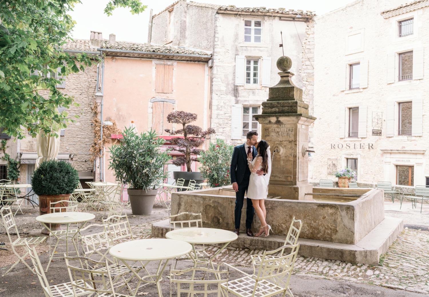 bride and groom pose at a fountain in gordes france