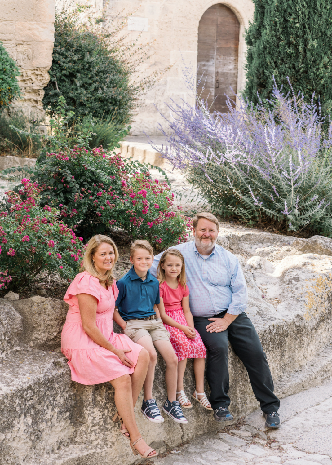 family sit surrounded by flowers in les baux de provence france