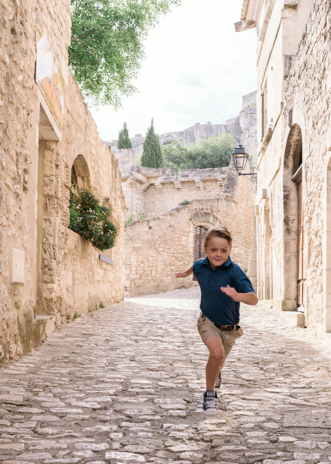 boy runs on cobblestone in les baux de provence france