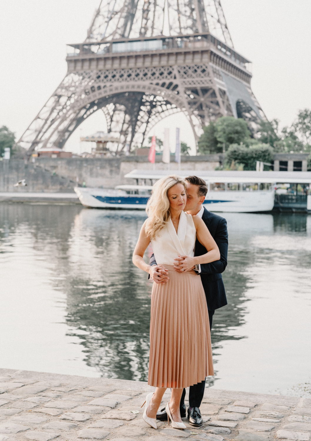 engaged couple embrace from behind at the eiffel tower