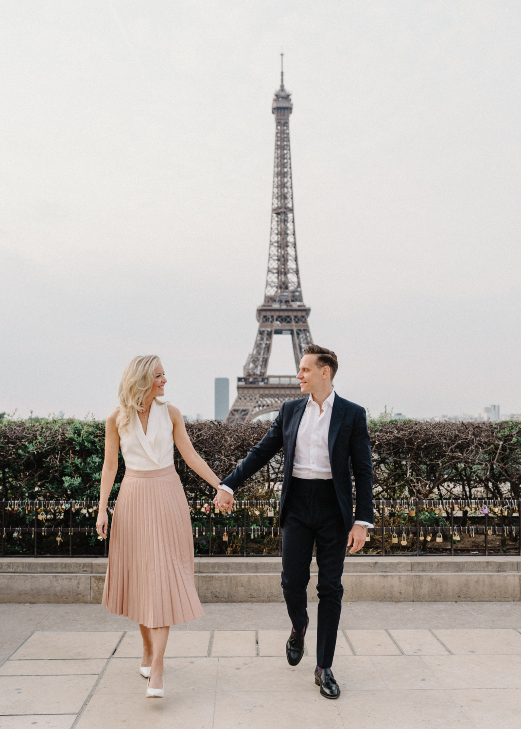 engaged couple laugh and walk at eiffel tower paris