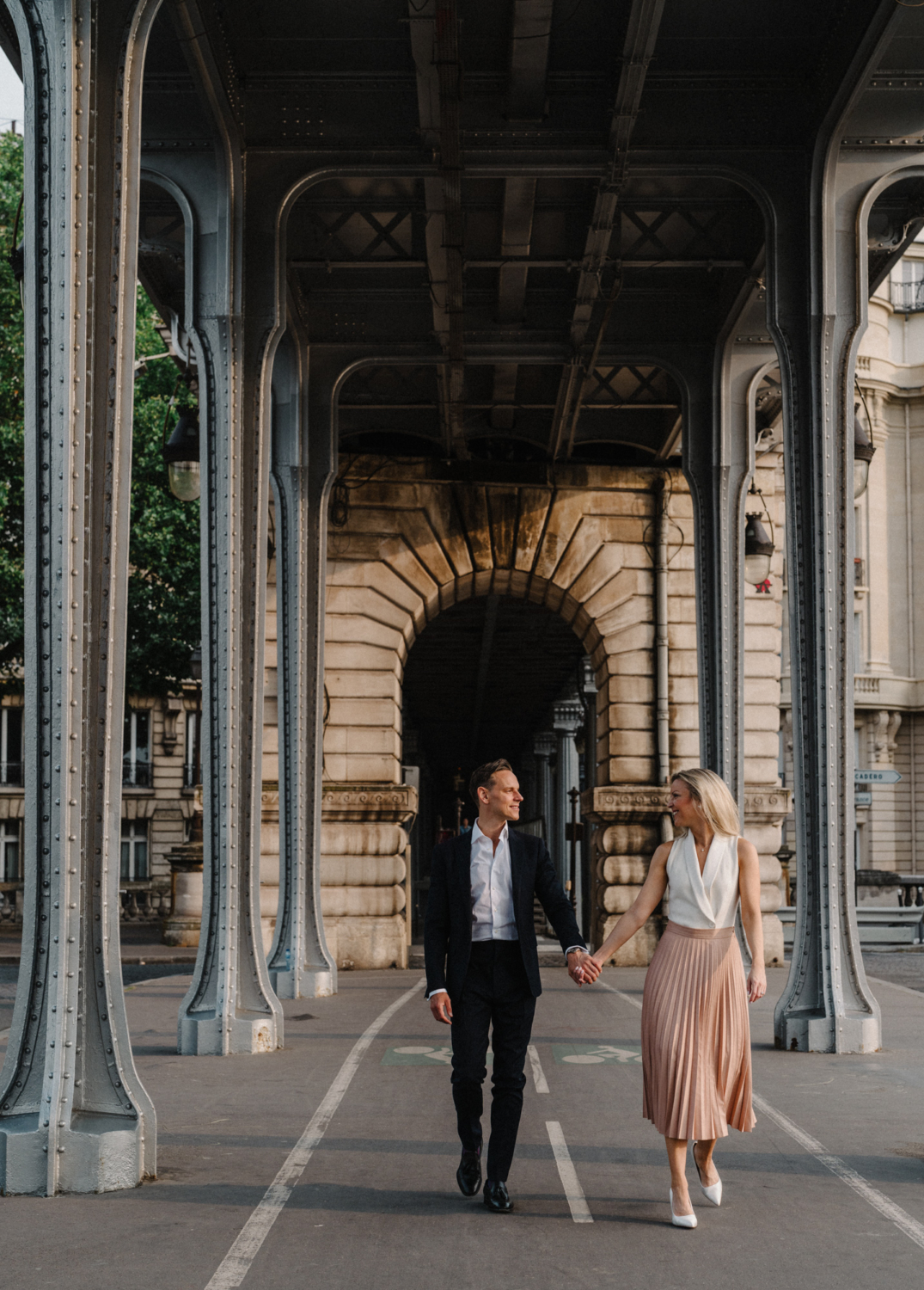 engaged couple walk hand in hand in paris