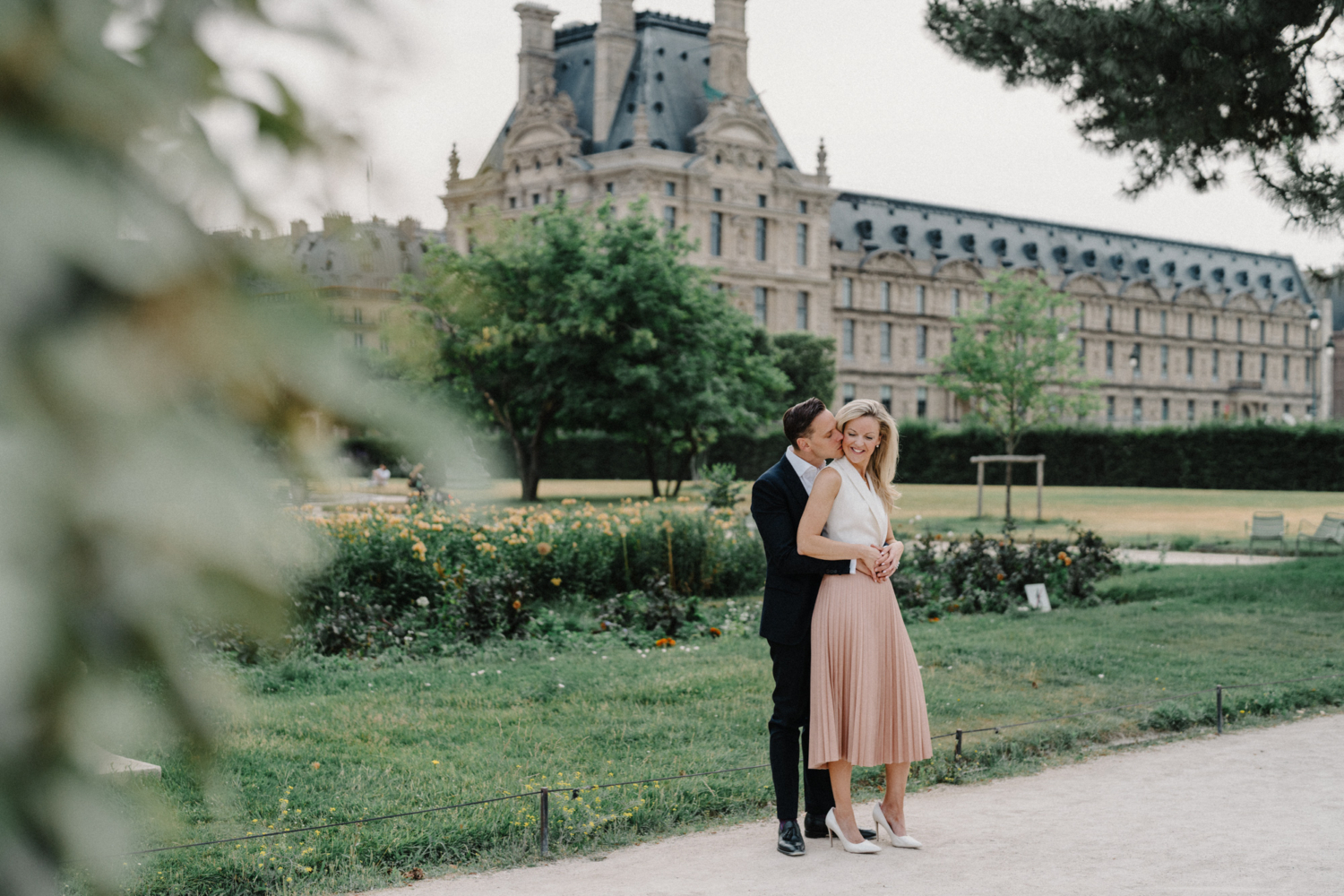 man kisses womans cheek in tuileries gardens paris