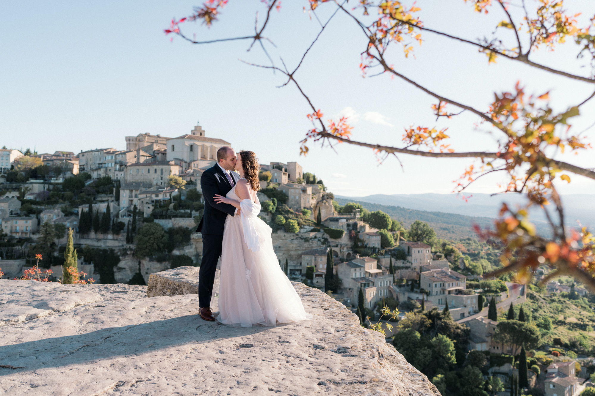 newlywed couple share kiss on rock in gordes france