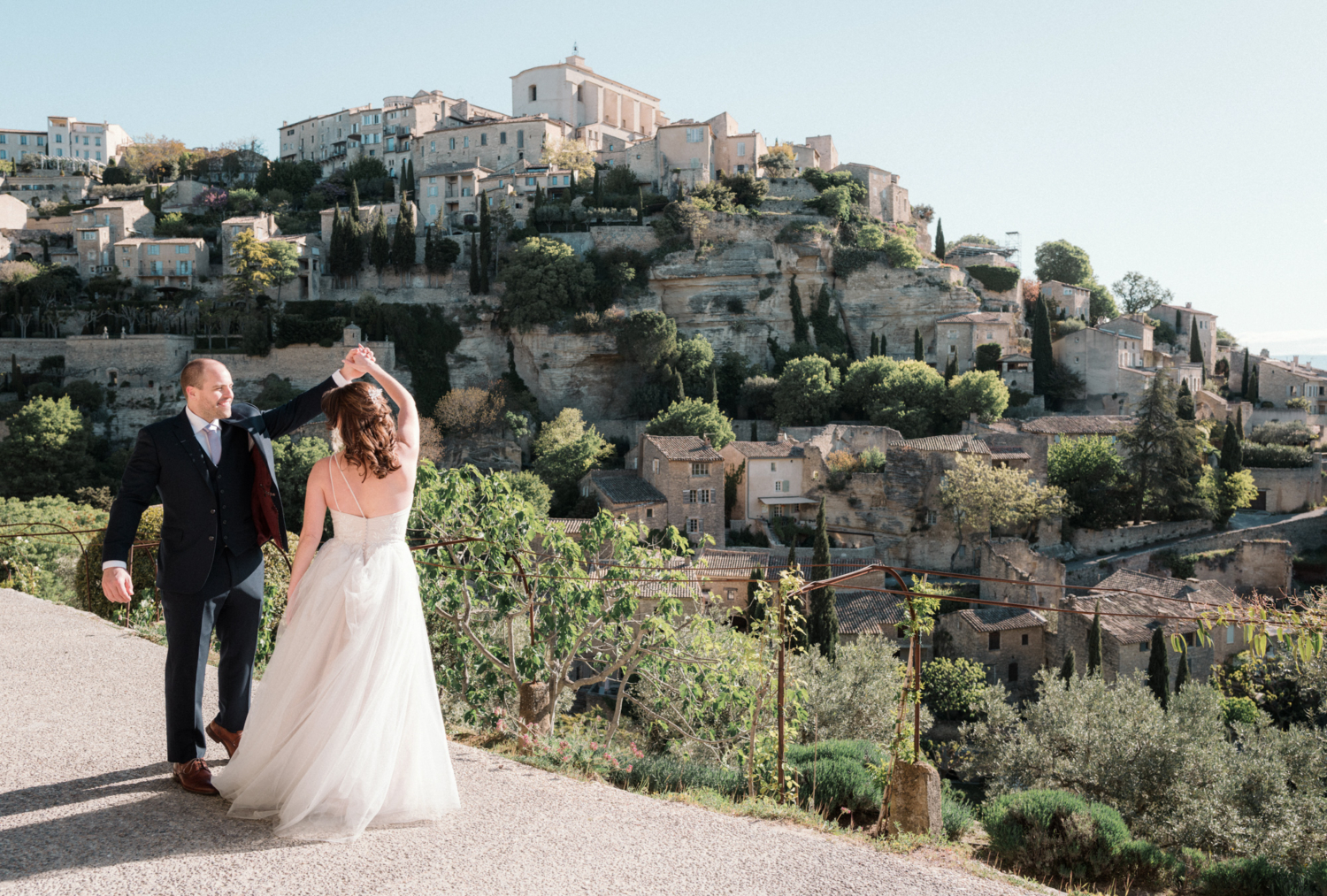 newlywed couple dancing with view of gordes village