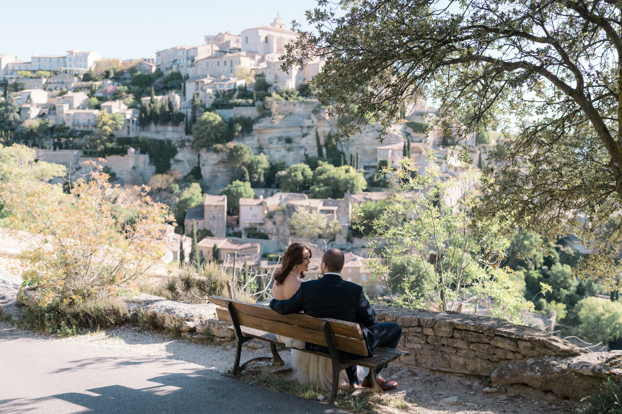 newlywed couple sitting on a bench in gordes