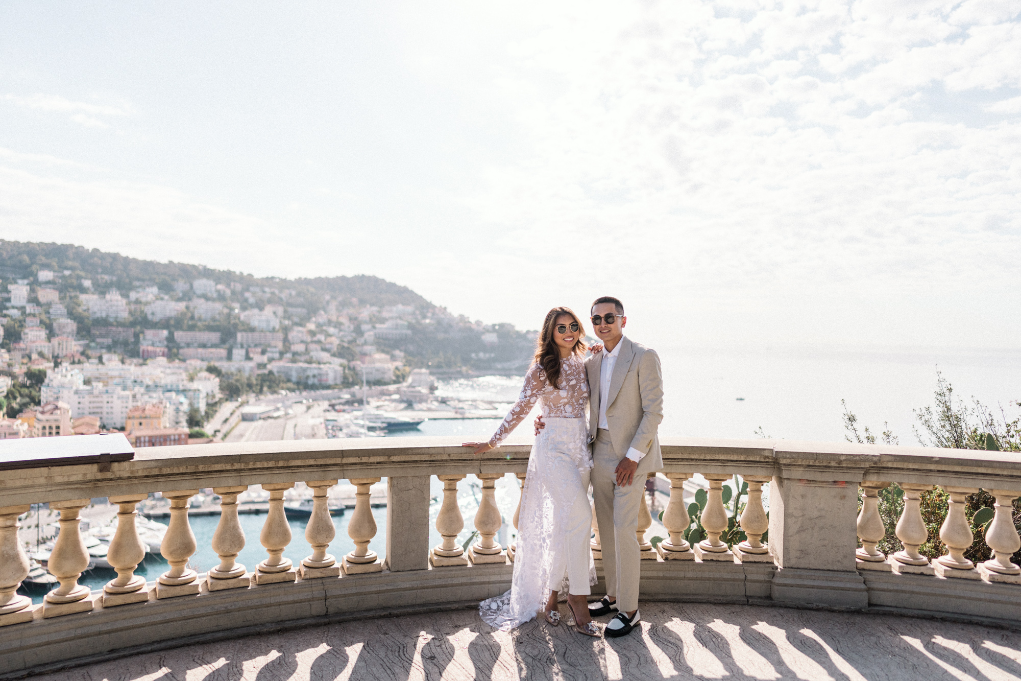 smiling couple wearing sunglasses overlooking marina in nice france