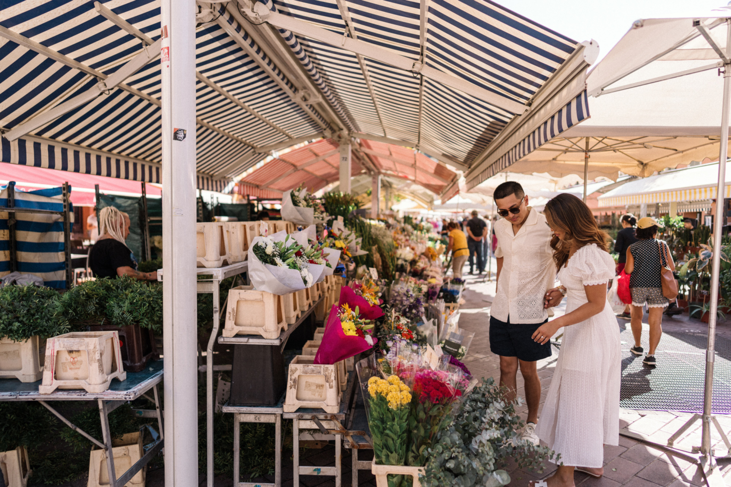 engaged couple look for flowers at the market in nice france