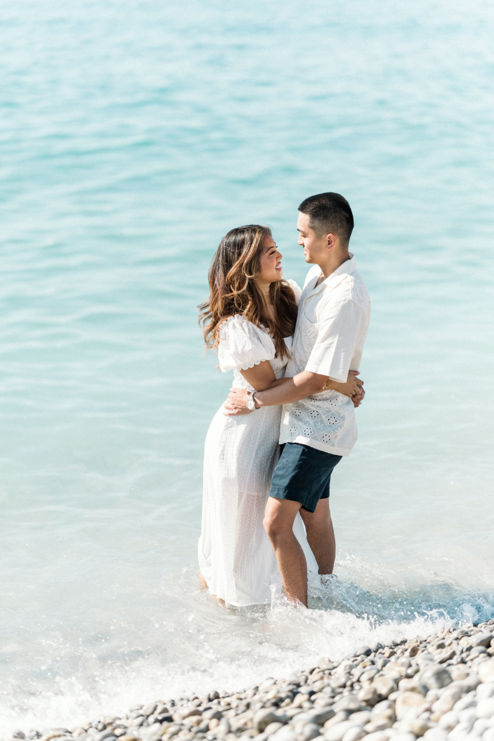 couple dressed in white embrace in the sea in nice france