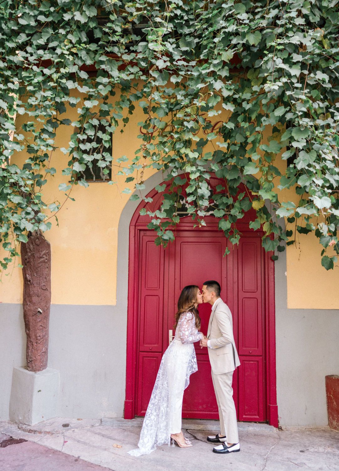 couple kiss in front of red door in nice france