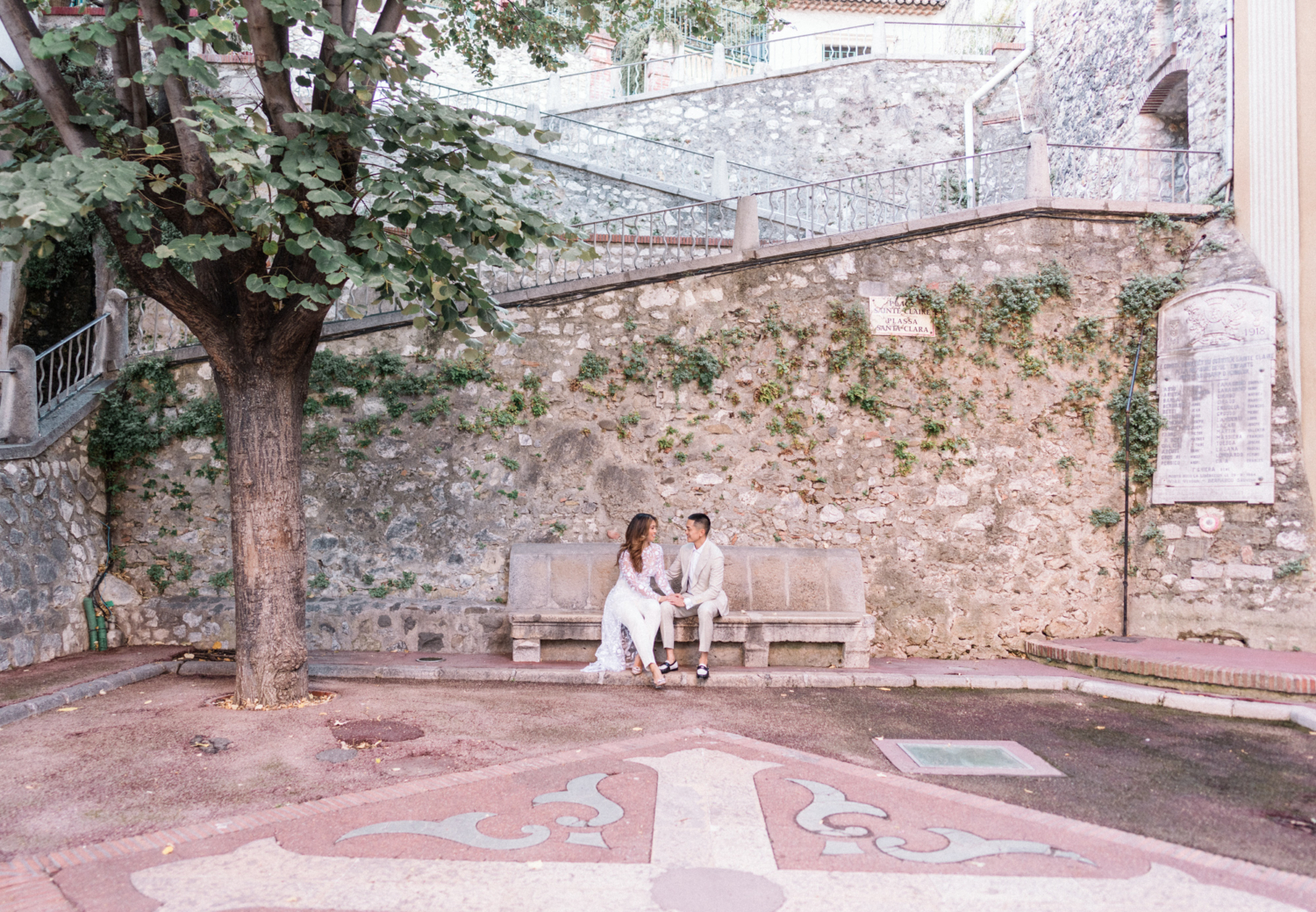 engaged couple sit on bench in nice france