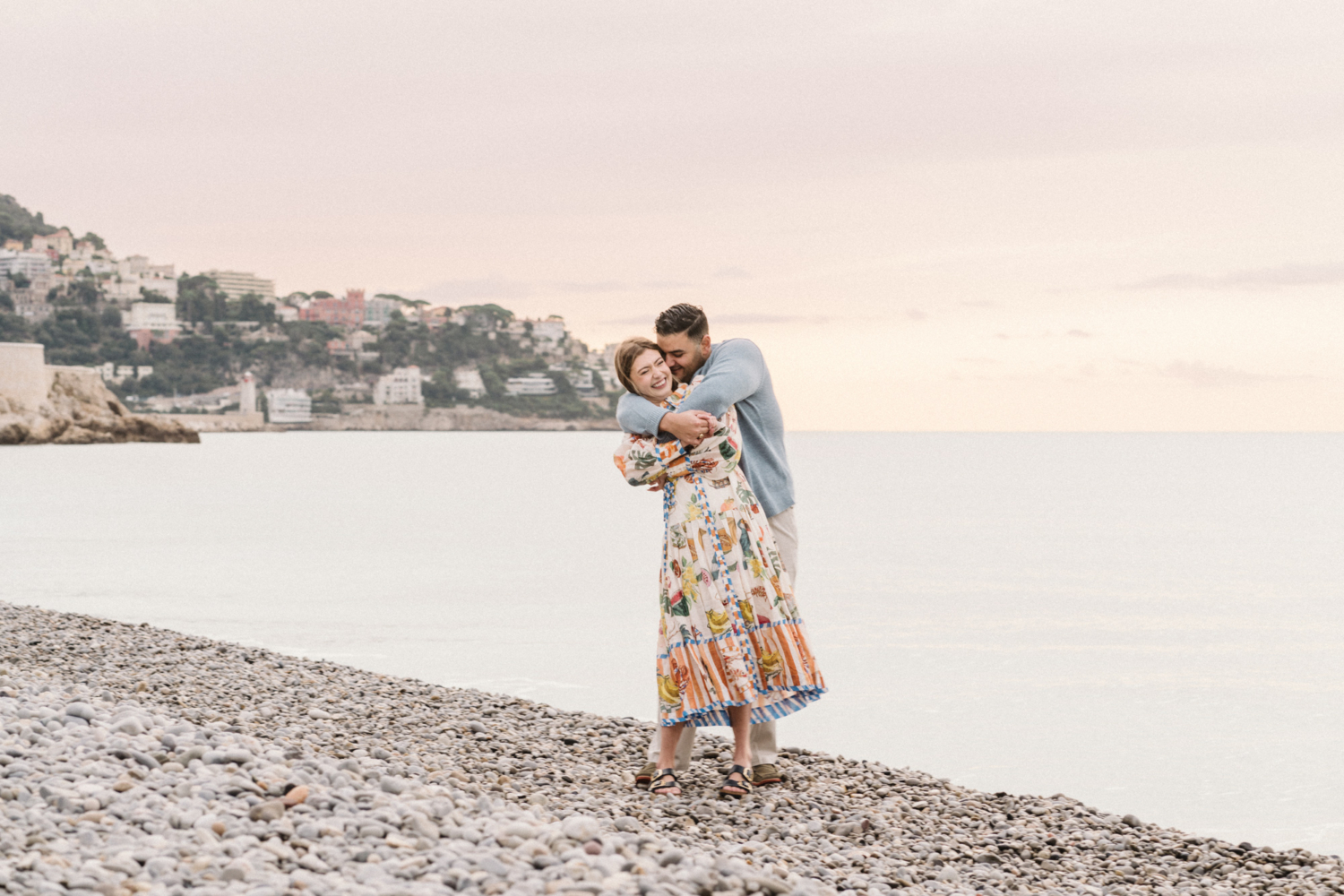 man hugs woman from behind on beach in nice france