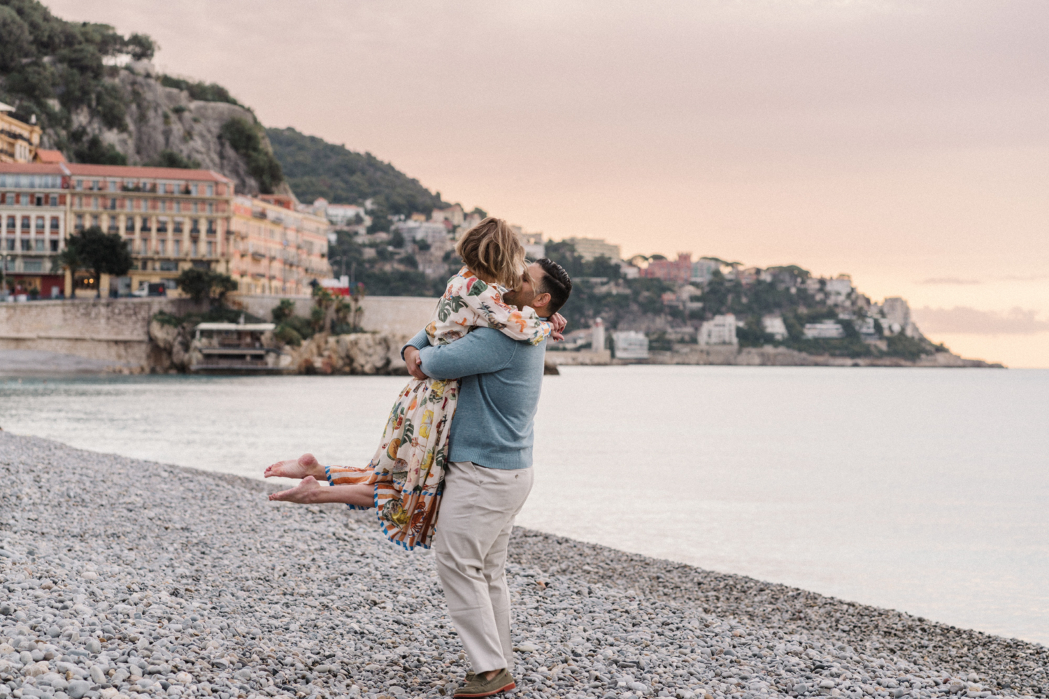 man twirls woman on beach in nice france