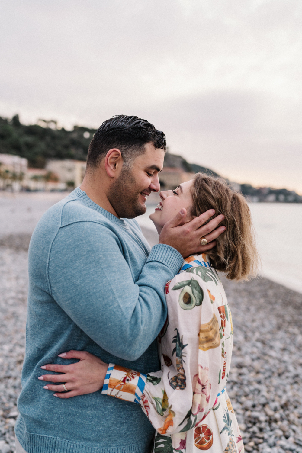 man holds woman's hands in his face at beach in nice france