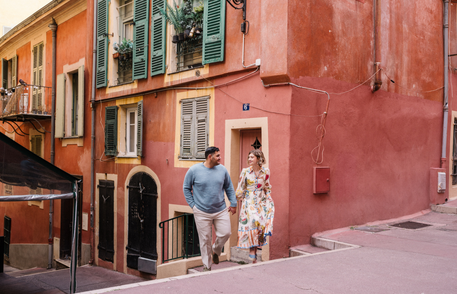 couple walking in nice france with colorful buildings