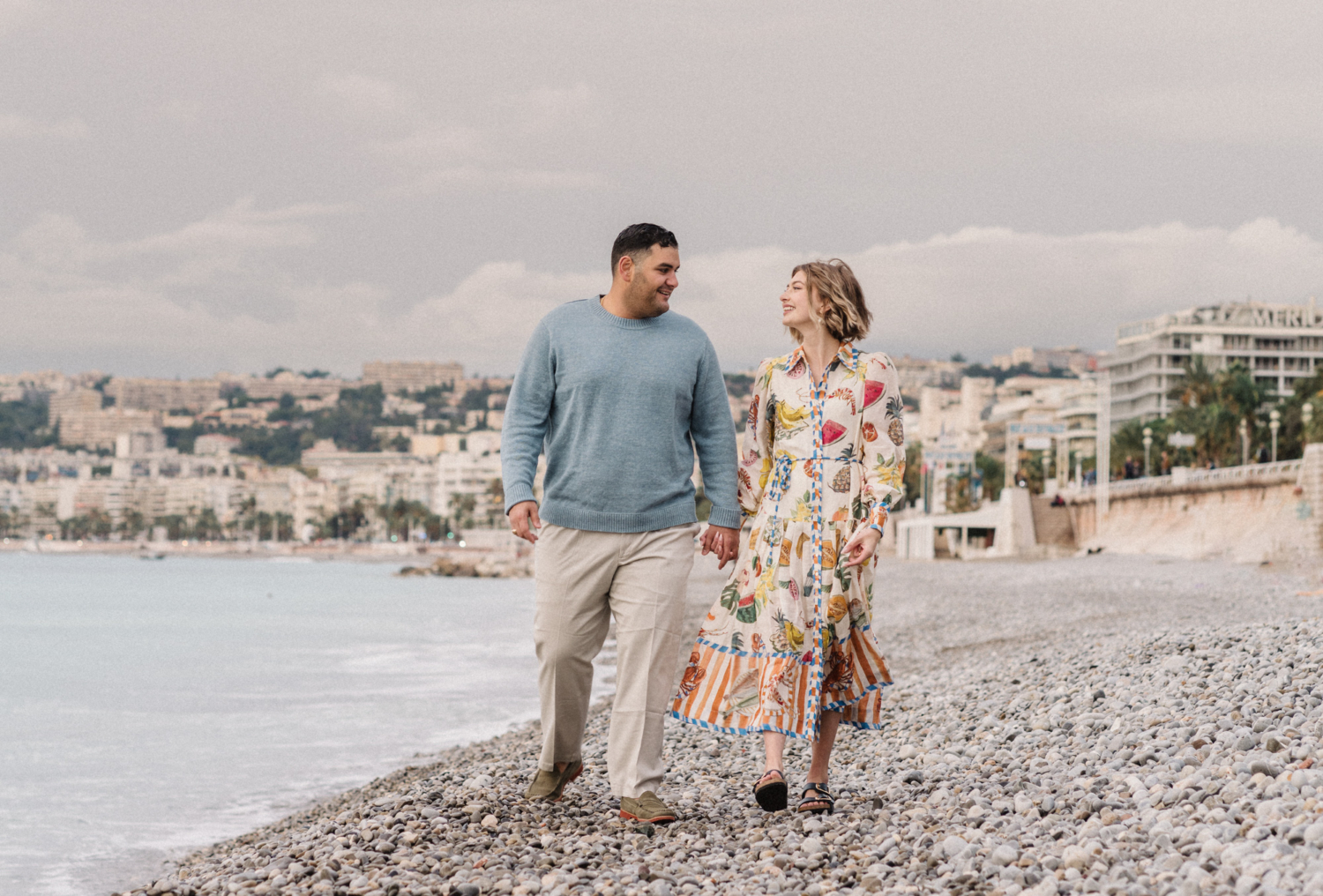 married couple walk hand in hand on beach in nice france