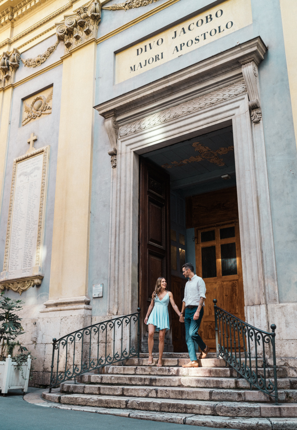 joyful couple walk down stairs in nice france