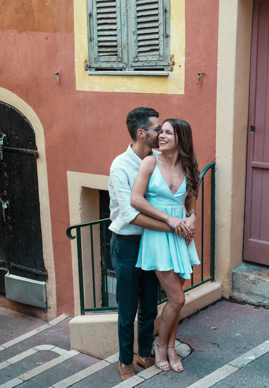 man whispers in woman's ear and she laughs in nice france