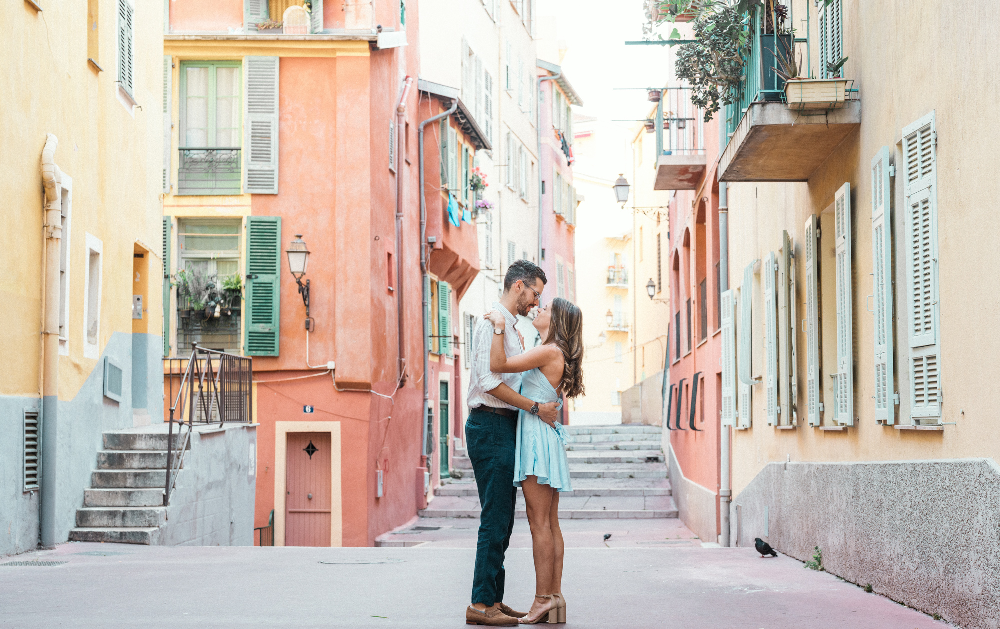 cute couple embrace with colorful buildings in nice france