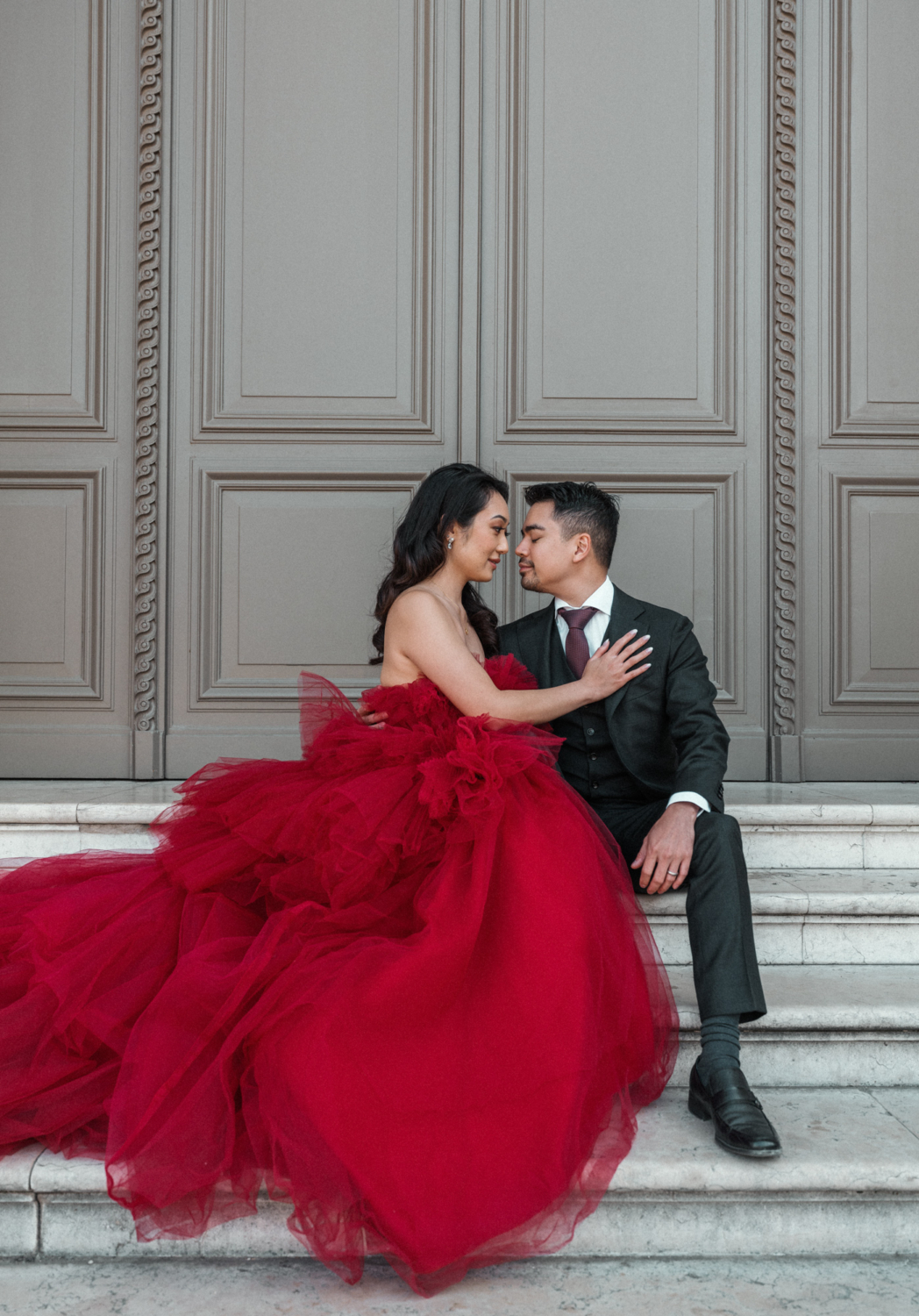 asian couple pose on staircase at louvre in paris