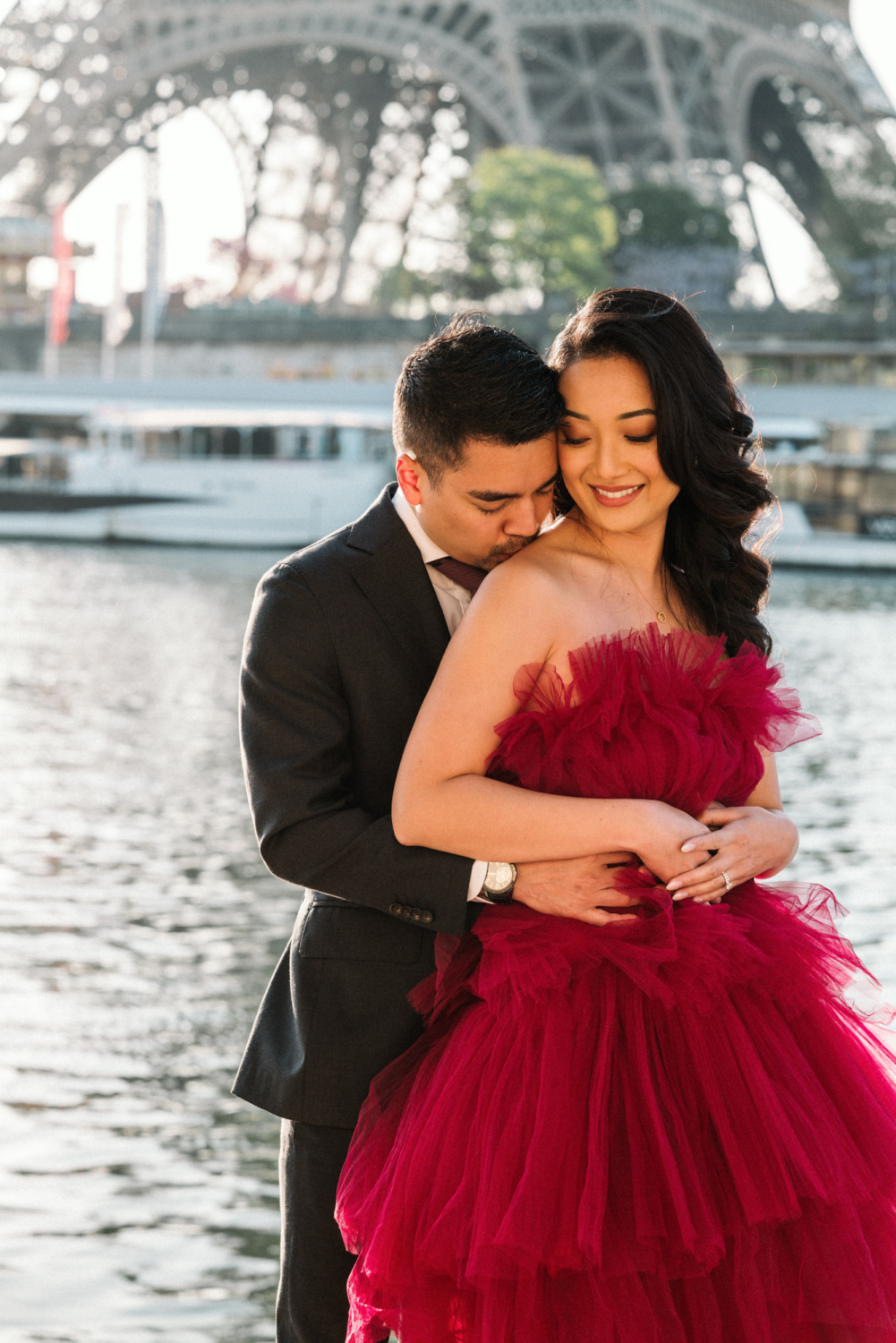 asian couple embrace at eiffel tower