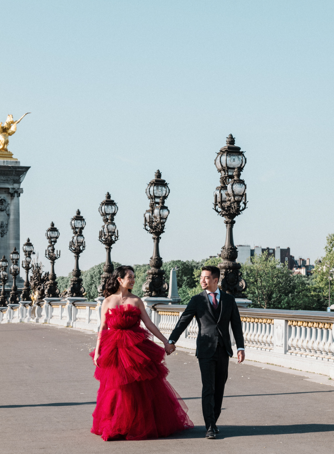 asian couple walk on pont alexandre in paris
