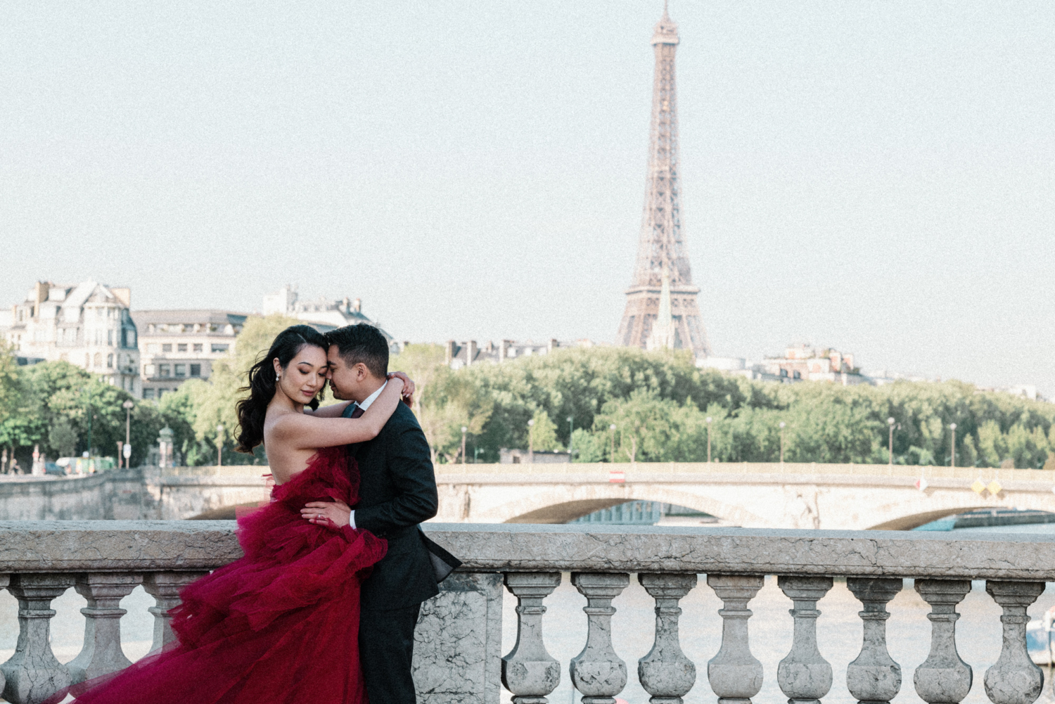 asian couple embrace with view of eiffel tower