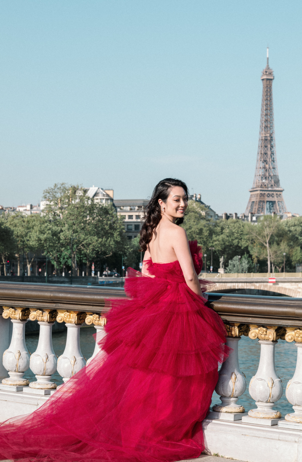 asian woman poses in red gown with eiffel tower in background