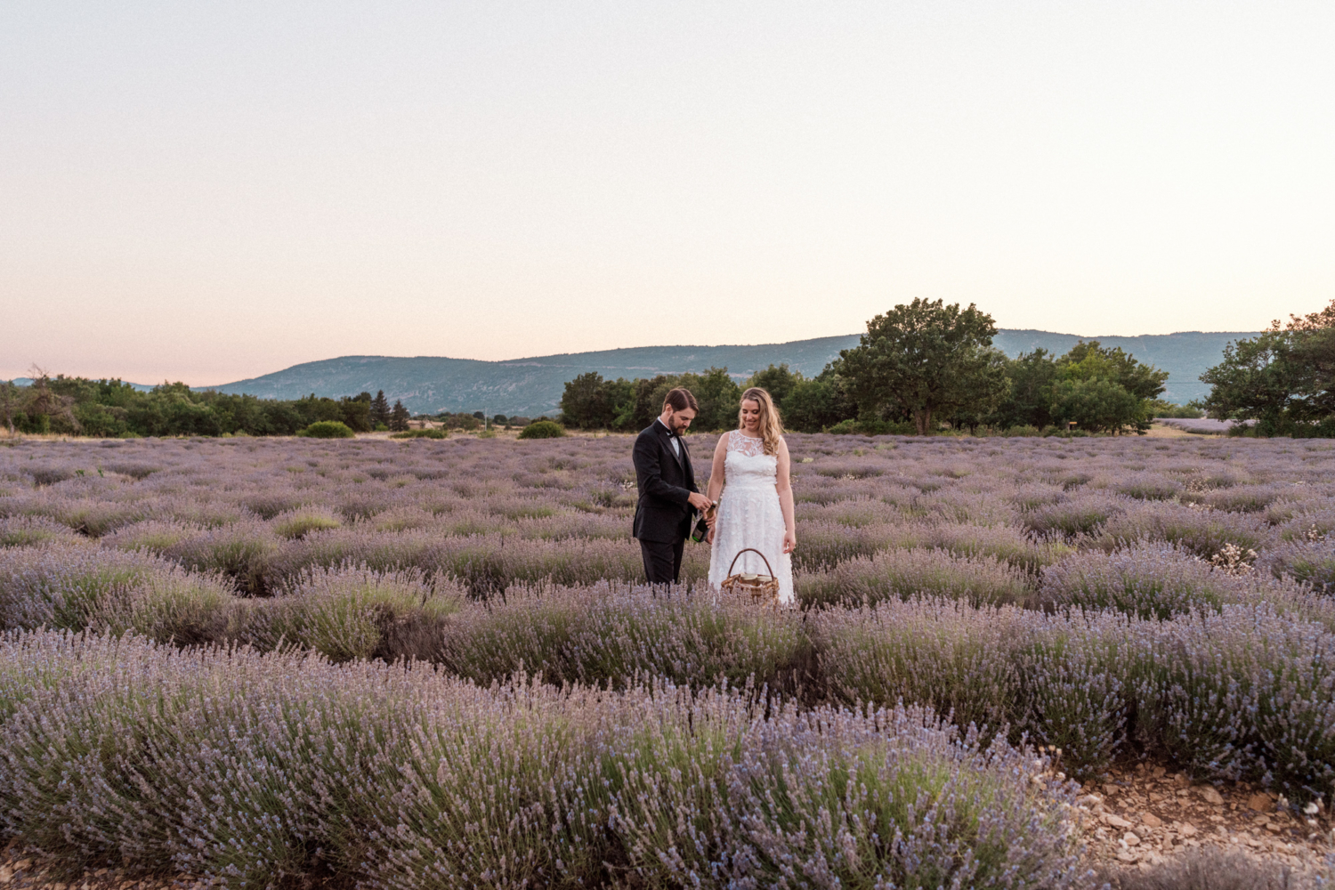 newlywed couple in the lavender fields of provence with picnic basket