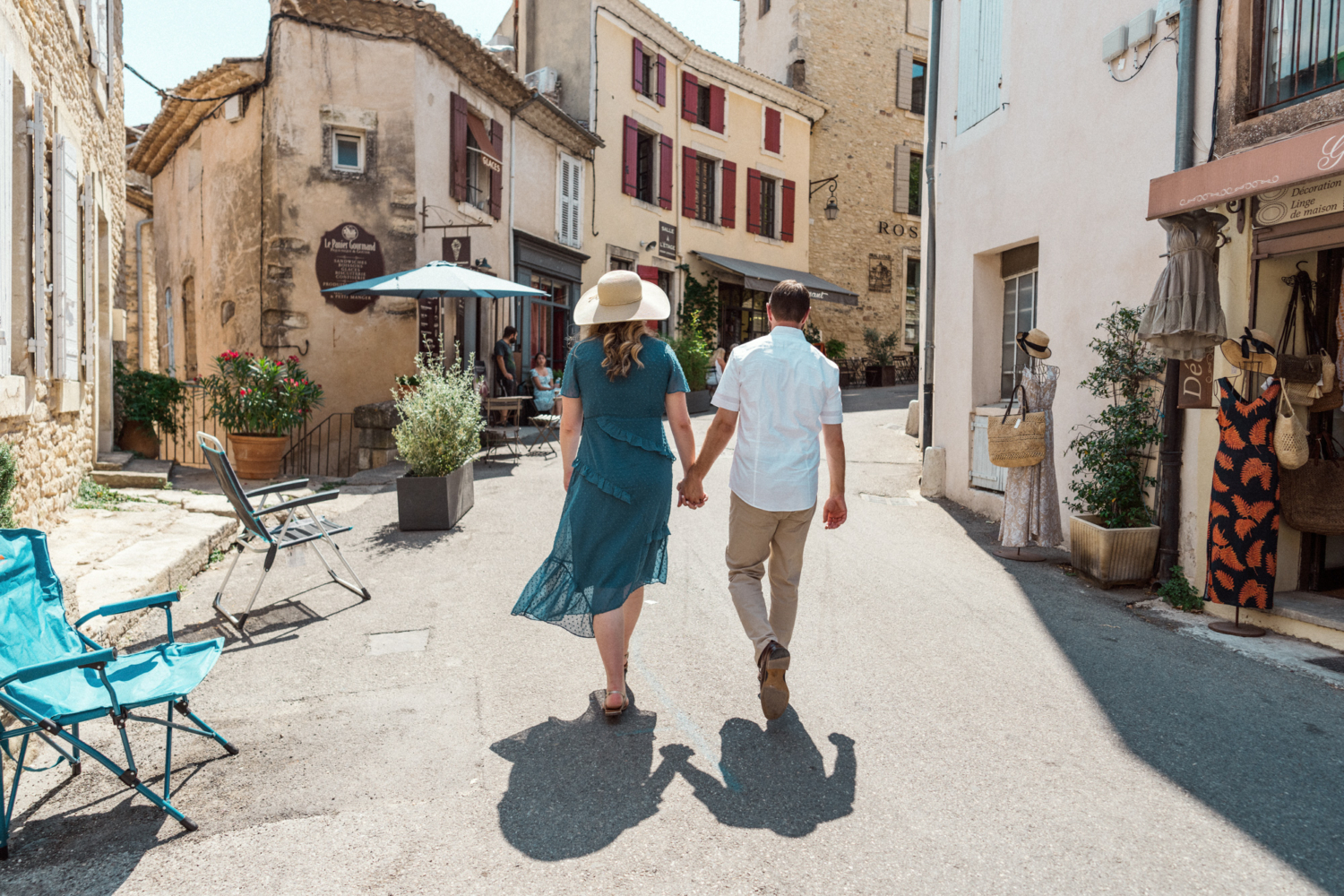 husband and wife walk hand in hand in gordes