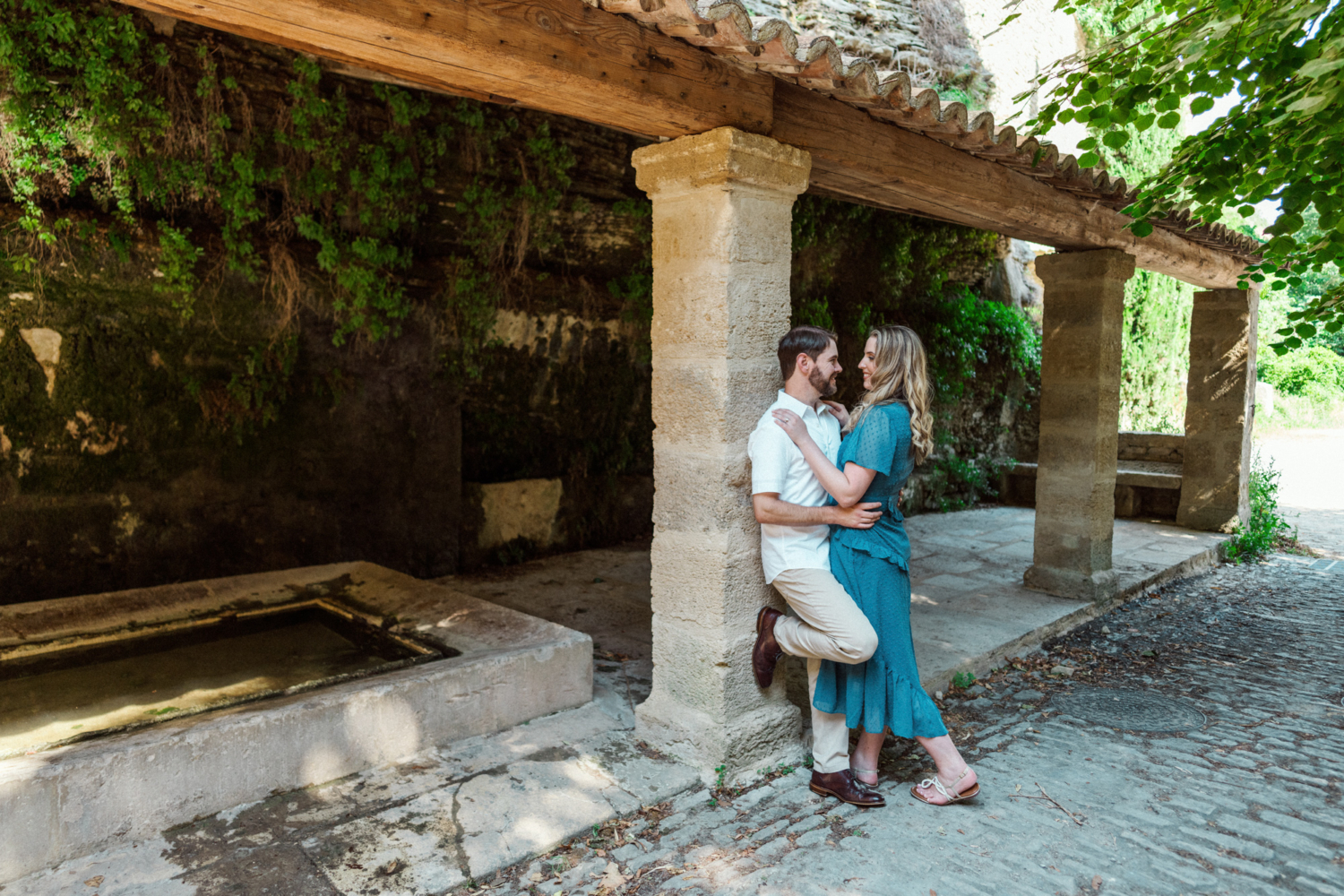 couple embrace near an old lavoir in france