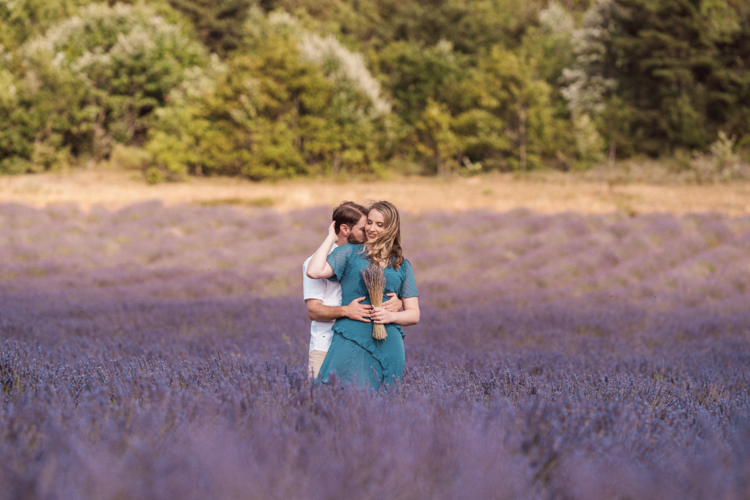 man kisses woman's neck in lavender field