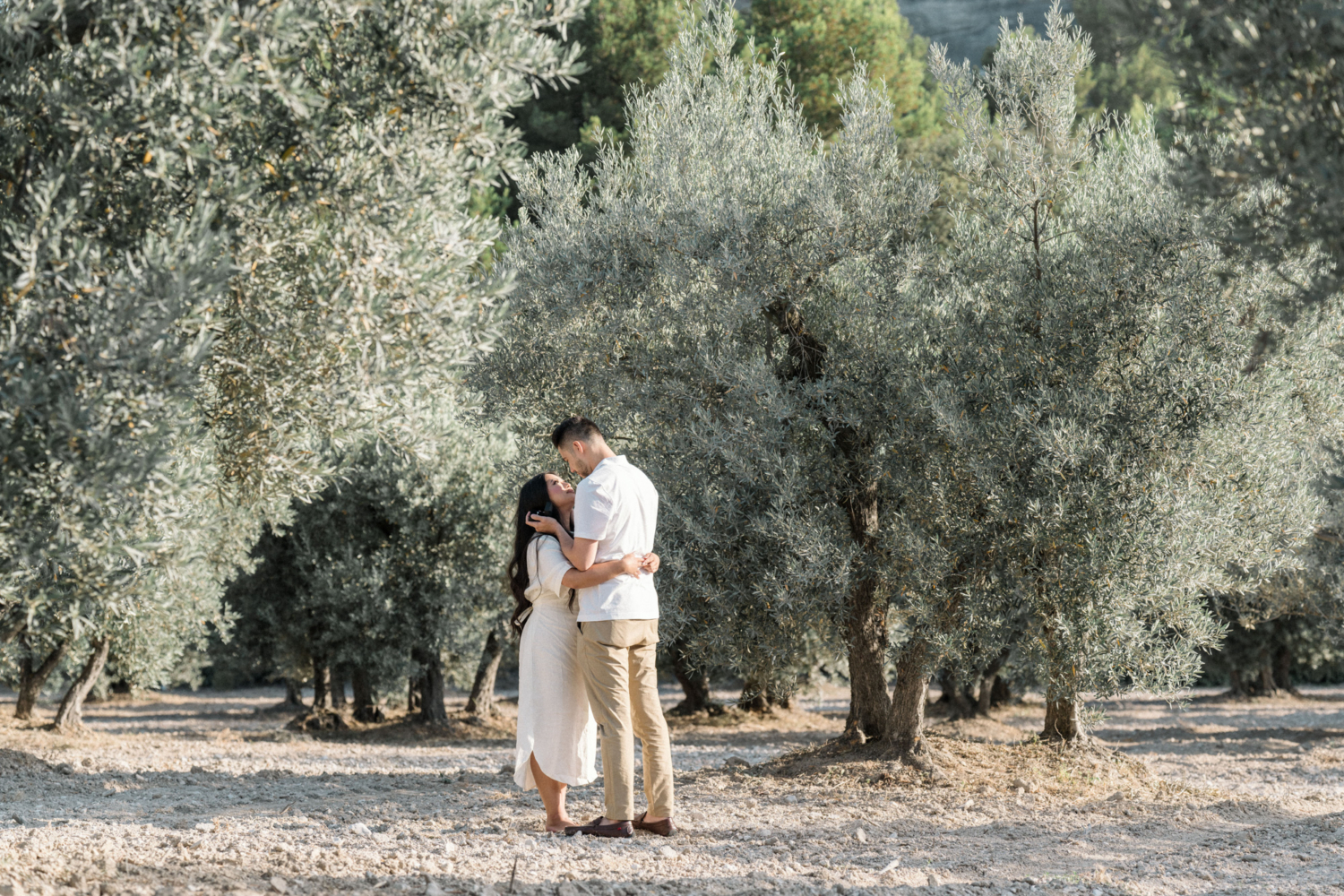 couple embrace after getting in engaged in olive grove