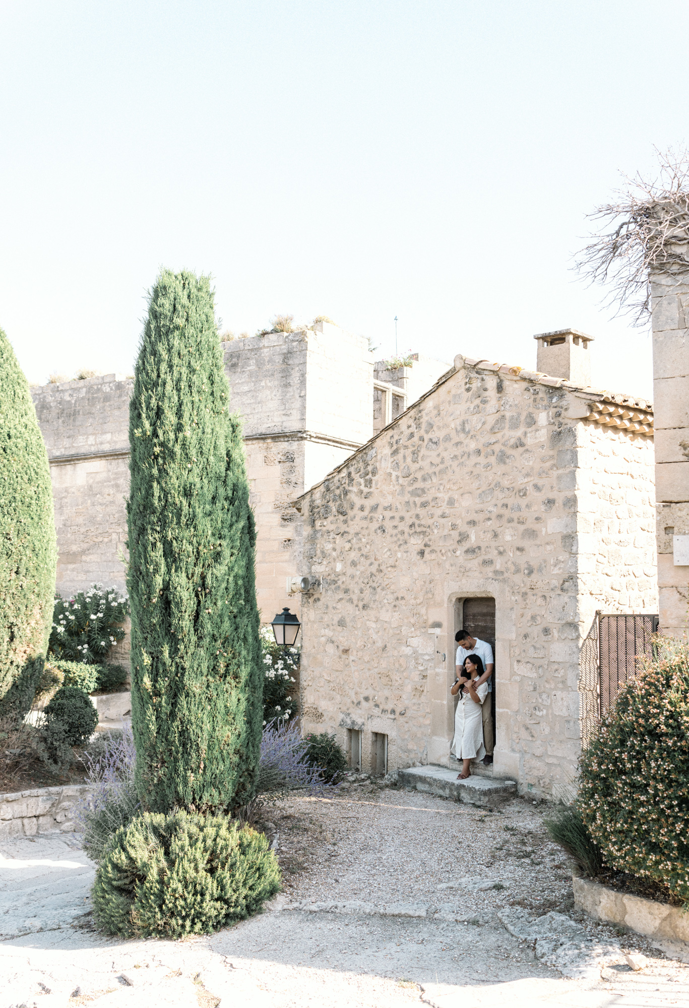 man and woman embrace near chapel in les baux de provence during Engagement Photos In Provence