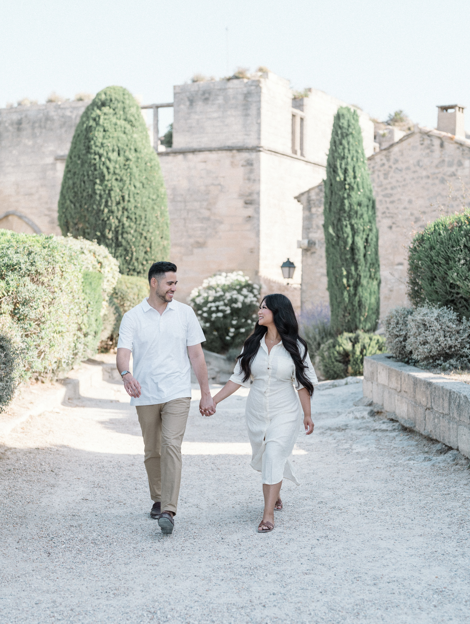 man and woman dressed in white walk in medieval village